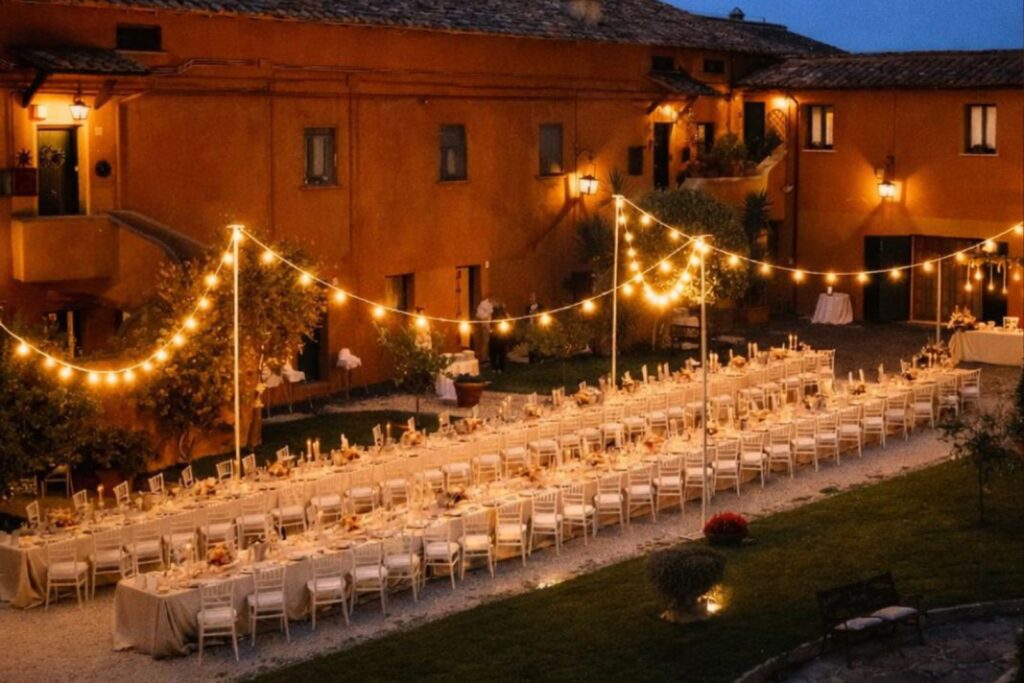 Allestimento per matrimonio all’aperto con lampade sospese in fibra naturale e illuminazione serale calda